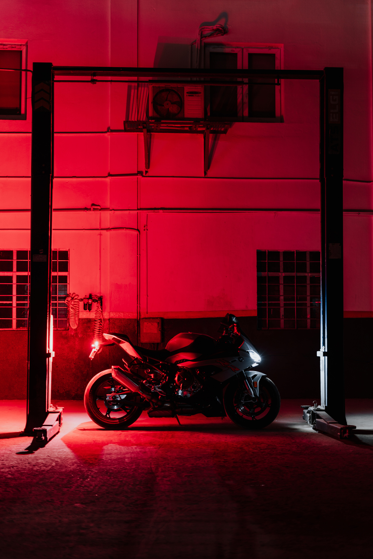 Black Motorcycle Parked Beside Red Wall